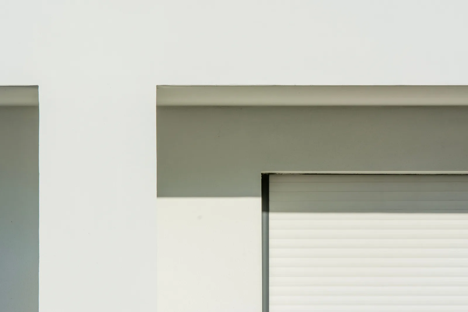Detalle de fachada residencial con aislamiento exterior SATE y encuentro de ventana bien rematado.